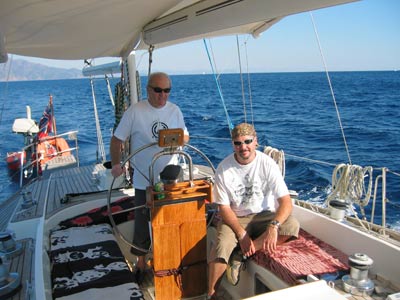 Jamie & Liz agreed it was time to break out of the “Black Hole” and actually sail in to the Mediterranean. Within Marmaris bay katabatic winds and unpredictable breezes make sailing challenging. We entered the Sark Bogazi straight, which proved to be much wider than it appeared on the chart, and the winds picked up so we commenced tacking and making good progress. After about ¾ mile we broke out and started some serious stuff with 3 sails out, proving that with a ketch rig you don’t need the mainsail if you want to cruise comfortably. Before long, however the Skipper decided it was time to turn right round a full 180 degrees and head due west towards Turunc, which is where we would be mooring up for the night. The wind was dropping before but now it was down to a whisper and then as we reached the wind shadow of the high hills facing us, we almost stopped. So it was on with the engine and aim for the beach.  Neither Jamie nor Liz had been here before so we all consulted Rod Heikel’s book, which seemed optimistic about safe anchorage. Sure enough there were so many Turkish boats (especially the mini-gulets) that we abandoned the idea of tucking ourselves right in but took the more prudent option of anchoring just in front of the bathing area.  Swimming in Turunc Source: M&L Furlong  We had just got our swimming togs on when a Turkish boat stuffed full of English tourists came right up behind us and dropped anchor- obviously we were in his favourite spot! Fortunately, they did not stay too long and eventually left us in peace, except yet again an ice cream man came by yelling out his wares. After that, we were able to swim and snorkel in crystal clear water before watching the sun go down as we sipped our aperitifs on deck.  Then it was the dreaded wobbly blancmange ride to the village quay where a “kind local” helped us ashore. Turunc is a small resort with a funicular railway (no doubt because it’s on a mountainside). Although it gives the impression of being quite remote, it’s actually touristy but not too bad. After a browse amongst the tourist tat in the shops, looking for a bracelet for our granddaughter Jamie & Liz spied a bar for a top up and promptly sat down, whilst we headed for the nearest cash machine! In ordering drinks for us we are impressed with Jamie & Liz’s improving Turkish vocabulary. We stuck to wine for our aperitif before we settled on an eatery. We ended up on the front looking out into the bay at the restaurant that the “kind local” manages, for an excellent meal with plenty of local red to wash it all down, but it’s a cash only bill. Then back into the wobbly inflatable for a smooth ride out to Esper (with torch clutched tightly in hand). At this point Lesley opted for her bed, but Jamie suggested opening “that bottle of red you brought from England”. Since Mike is so weak willed he said “what a good idea” when in fact he had already had too much. Whilst quaffing more wine and noticing that Esper had sprouted and extra 2 masts, something flashed past him in the dark and then zoomed back again behind him. It was Millyu showing off her prowess at lightning reactions and seeing in the dark-it’s bit disconcerting until you get used to it. Well past midnight, Jamie said he was going to bed so Mike took the hint and staggered off feeling jaded. 